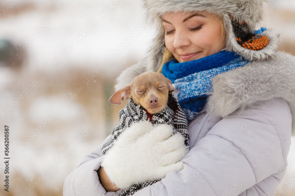 Woman hug warming her little dog in winter Woman hug warming her little dog in winter