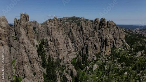 Needles Highway mountain spires South Dakota fly over into valley on summer day with blue sky and clouds