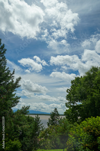 Shining sky with Cumulus clouds on the Amur river