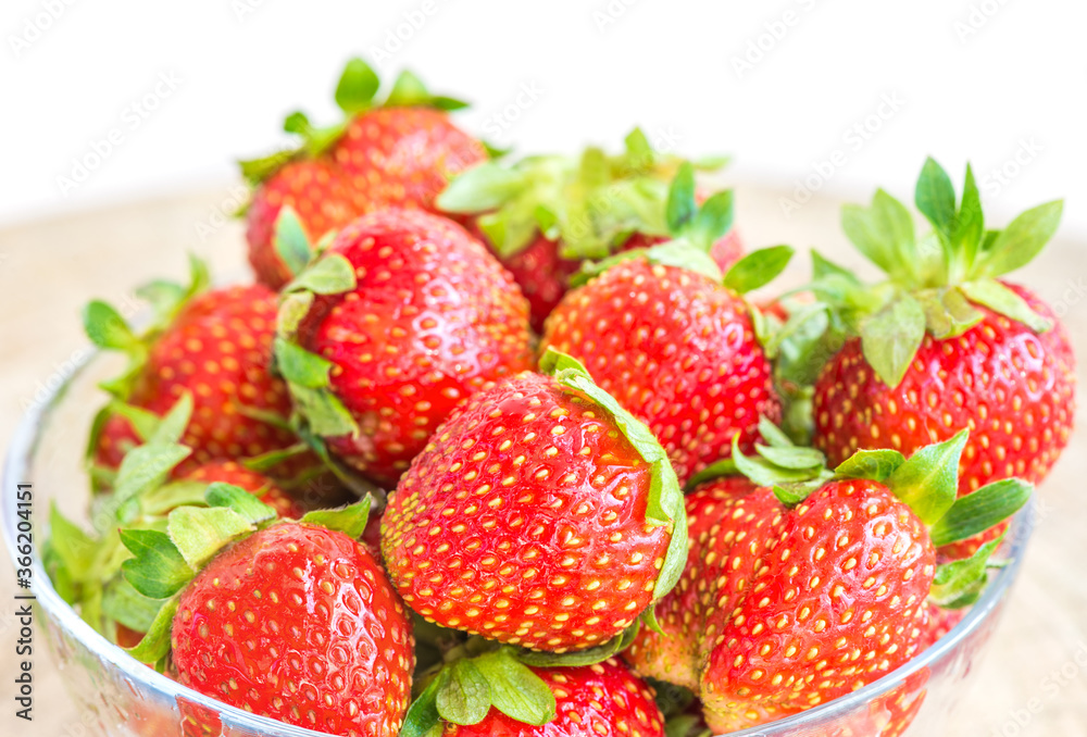 Strawberries in a plate on the table on a white background. Strawberries in a plate on the table on a white background.