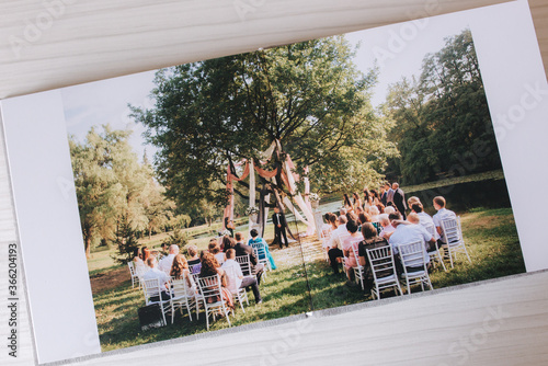 Open photobook with wrdding photo of beautiful couple on white wooden table photo