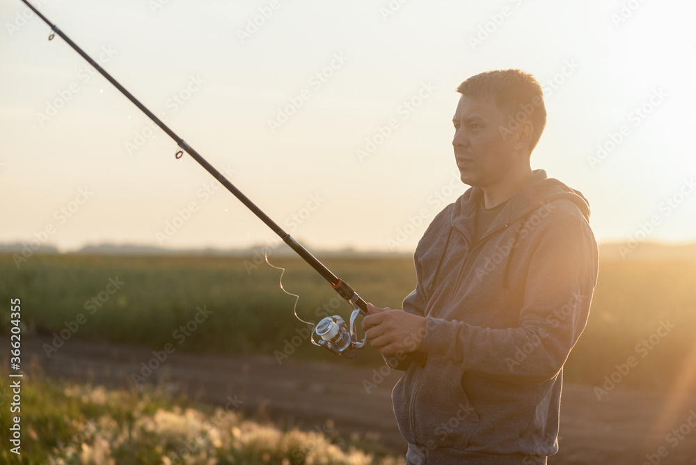 Fisher with fishing rod outdoors. Fisher with fishing rod outdoors.