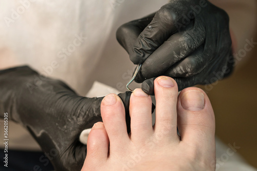 Process of professional pedicures. The concept of beauty and health. Chiropody master provides high quality services in beauty salon.