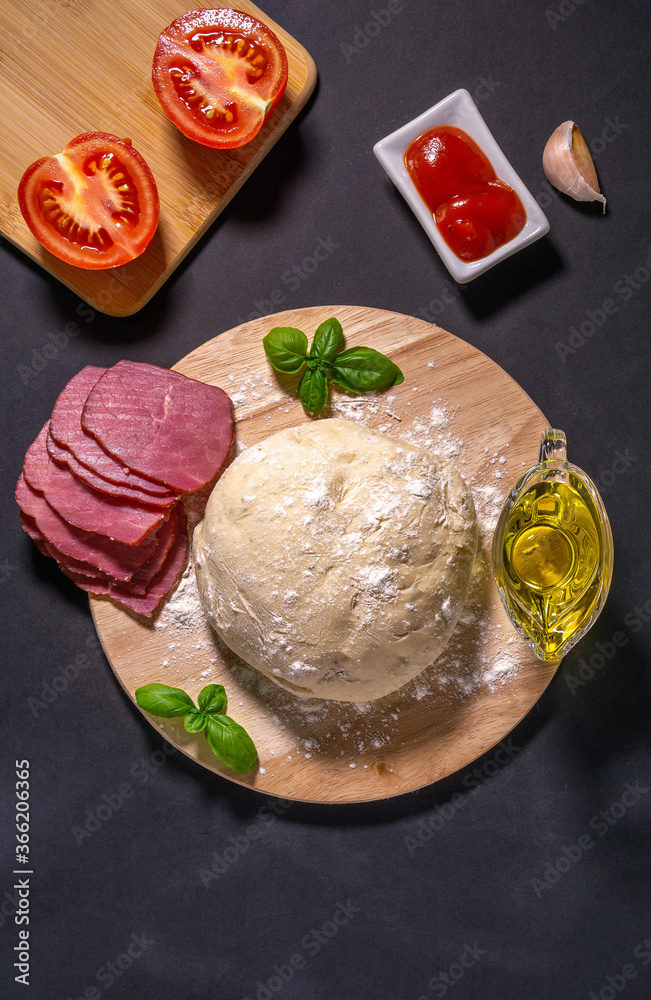 Ingredients for traditional Italian pizza Caprice Flat lay. ham, tomato sauce, garlic, spices, cheese, Basil, mushrooms. vertical photo, top view Ingredients for traditional Italian pizza Caprice Flat lay. ham, tomato sauce, garlic, spices, cheese, Basil, mushrooms. vertical photo, top view