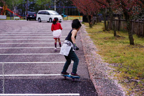 公園の駐車場でキャスターボードで遊ぶ男の子 photo