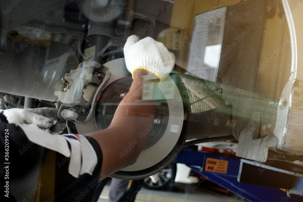 A mechanic repairing, grinding the brake disc and replacing worn out