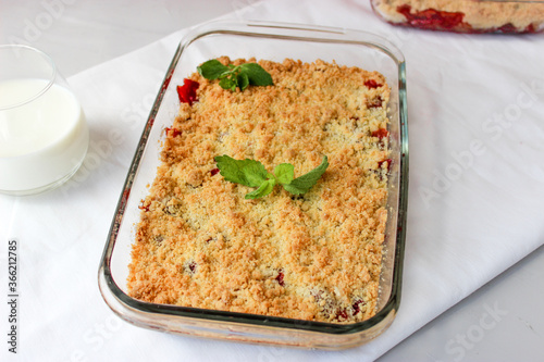 Ruddy crumble with field strawberries, decorated with a sprig of mint
