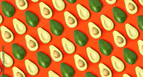 Flat lay composition with fresh ripe avocados on orange background