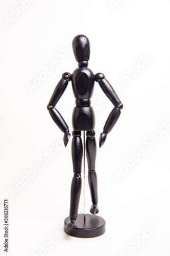 black wooden doll with hands on the lower back on a white background