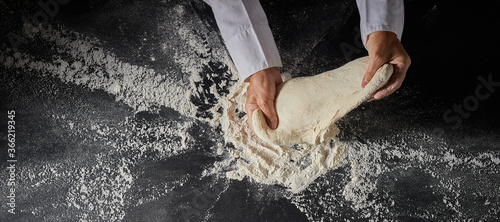 Chef stretching and kneading raw dough