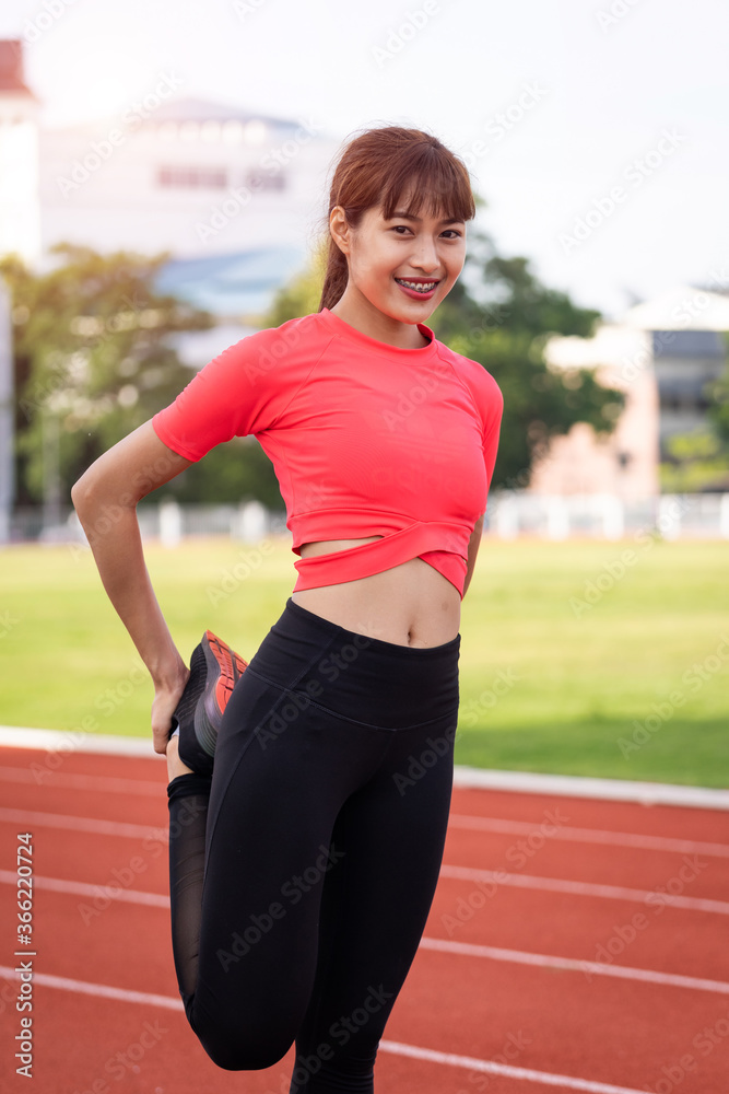 Portrait of a young woman runner warm up and stretching before workout in the morning in city stadium. Healthy and recreation stock photo. Portrait of a young woman runner warm up and stretching before workout in the morning in city stadium. Healthy and recreation stock photo.