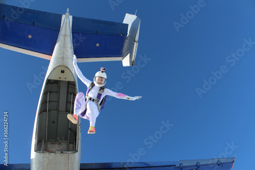 Skydiving. A girl just jumped out of a plane into the blue sky.