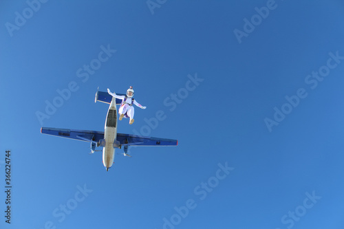 Skydiving. A girl just jumped out of a plane into the blue sky.
