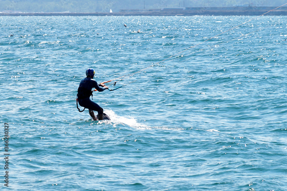 a man is kiting the sea on a sunny windy day
