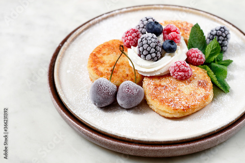 a plate with cheese cakes and berries