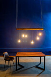 interior. wooden table, lamp hanging. blue wall.