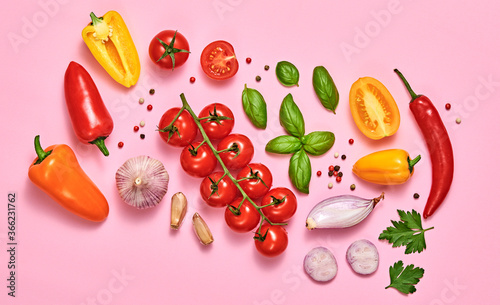 Tomato  basil  spices  bell chili pepper  garlic. Vegan diet food  creative composition on pink. Fresh basil  cherry tomatoes  bell pepper layout  cooking colorful concept  top view.