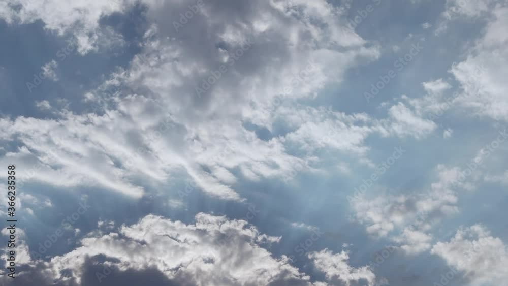 Time Lapse of White Gray Beautiful Clouds in a Clear Blue Sky. 4K Clouds. The Sun Shines Through Clouds in the Atmosphere Time Lapse of White Gray Beautiful Clouds in a Clear Blue Sky. 4K Clouds. The Sun Shines Through Clouds in the Atmosphere