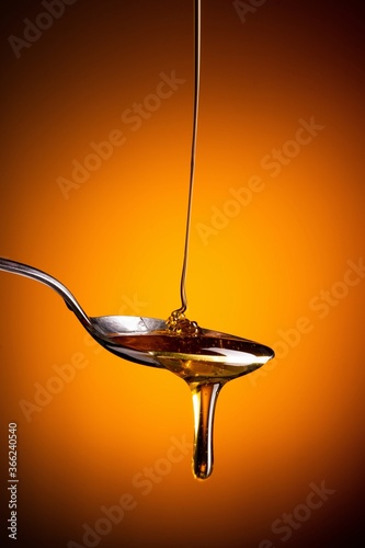 Organic honey flowing from the spoon