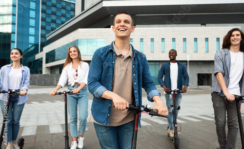 Buddies having ride on motorized kick scooters