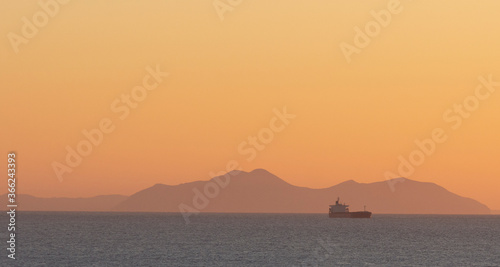 cargo ship crossing the sea at sunset