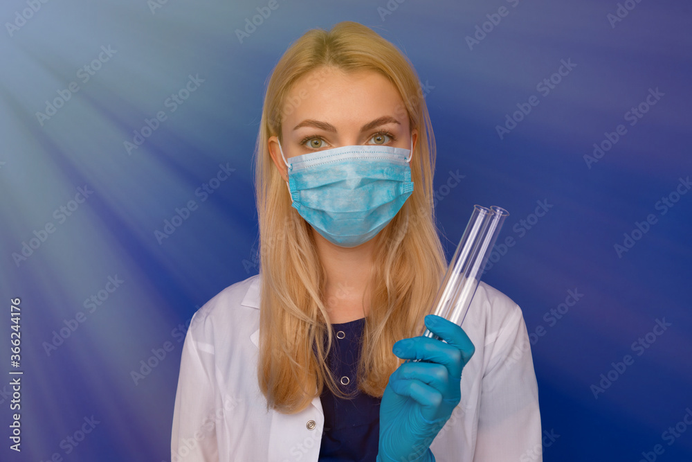 A girl doctor in a medical mask and gloves holding test tubes on a blue background A girl doctor in a medical mask and gloves holding test tubes on a blue background