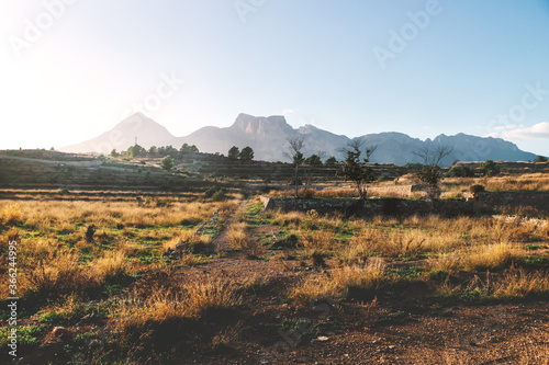 Former farmland on the countryside of Costa Blanca during sunset with lit mountains, La Nucia, Spain