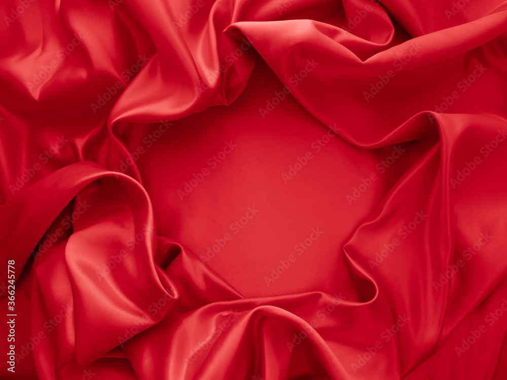 Beautiful elegant wavy red satin silk luxury cloth fabric texture with red background design. Card or banner.