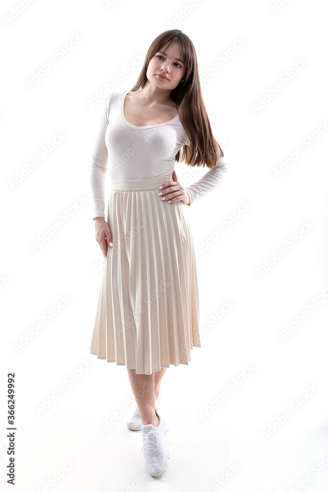 Beautiful girl in a white blouse and skirt posing on a white background Beautiful girl in a white blouse and skirt posing on a white background