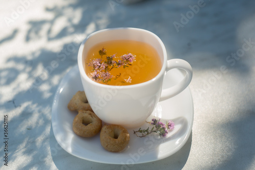 Black tea and thyme grass on a white background.Grass for health.Useful tea.Pink flowers