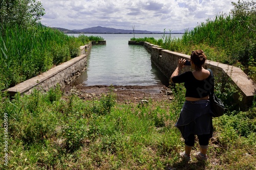 Fototapet girl taking a picture of the landscape using a smartphone