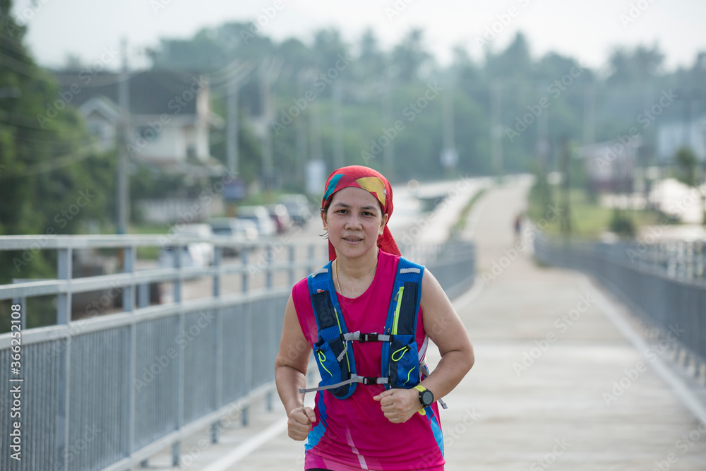 A portrait of asian woman runner running on flyover in park. healthy lifestyle fitness woman A portrait of asian woman runner running on flyover in park. healthy lifestyle fitness woman