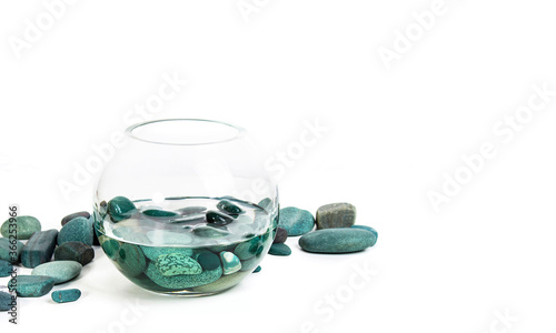 sea stones turquoise in water in a glass vase on a white background