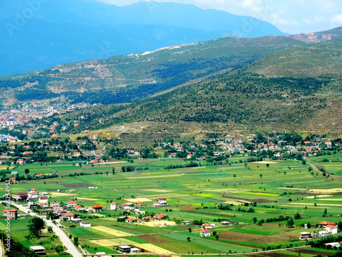 Natural countryside landscape with agricultural crops in valley field beside mountains. Transportation way from Macedonia to Albania.