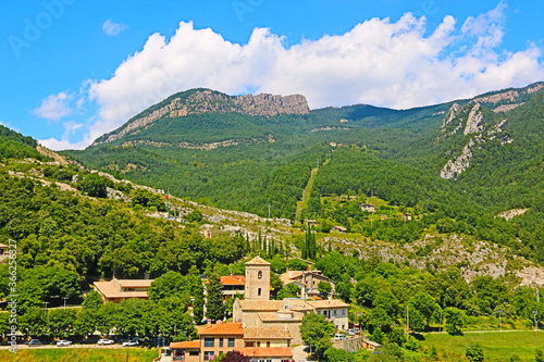 fondo paisaje con panorámica de un pequeño pueblo entre valles y montañas en verano