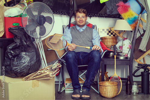 compulsive hoarding disorder concept - man hoarder with stuff piles sitting in the room photo