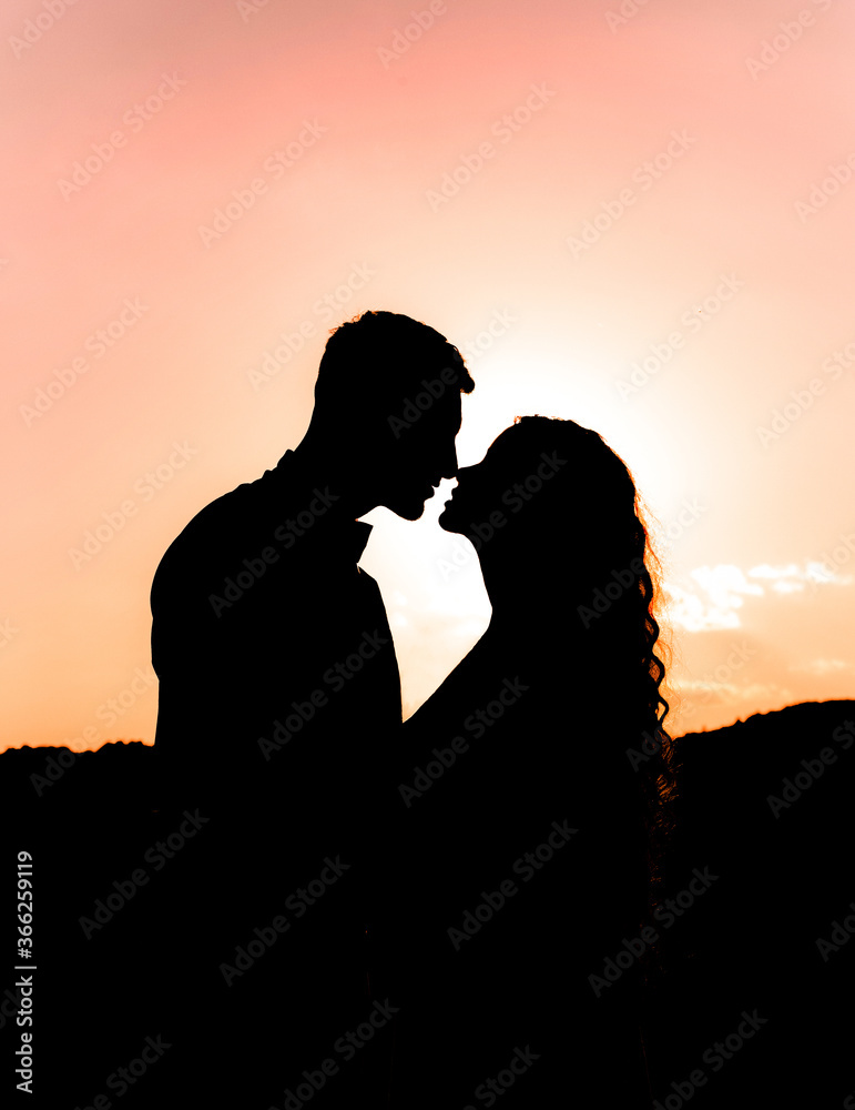 Amazing silhouette of a couple in love at sunset.