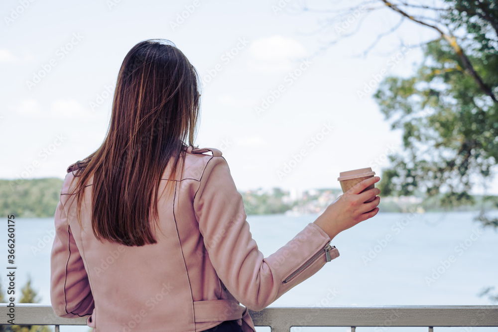 Female hand holding reusable coffee mug, turning his back. Zero waste. Sustainable lifestyle concept Female hand holding reusable coffee mug, turning his back. Zero waste. Sustainable lifestyle concept