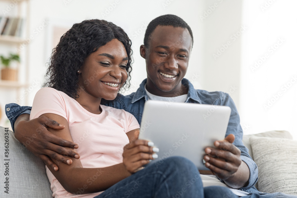 Closeup of smiling african man and woman using digital tablet Closeup of smiling african man and woman using digital tablet