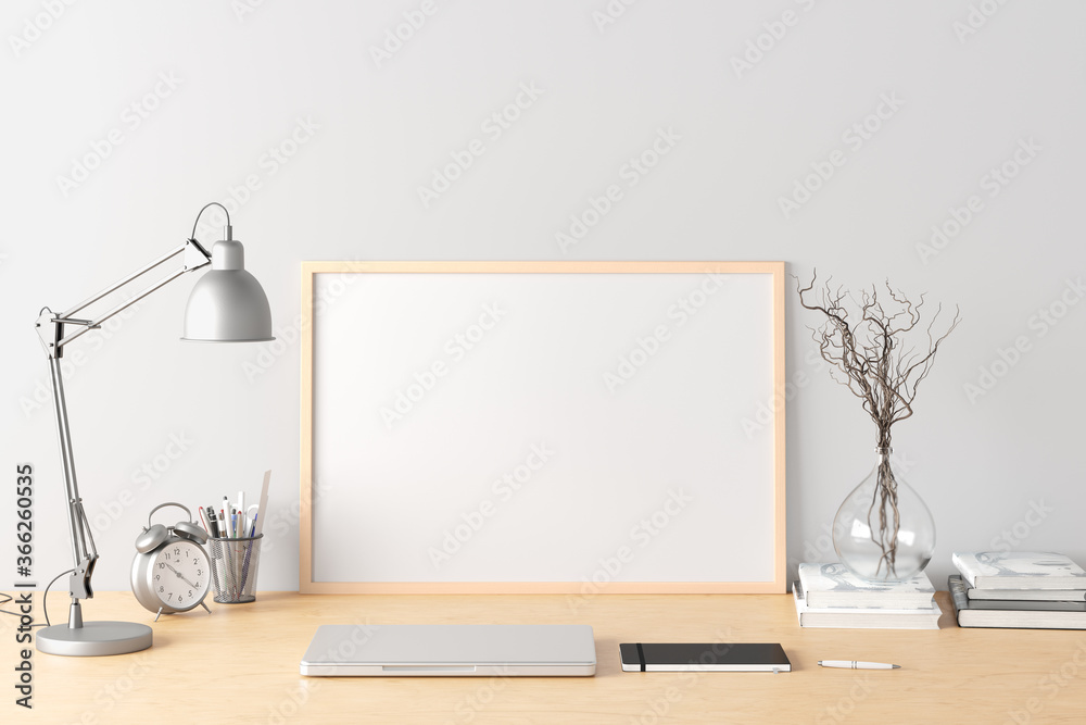 Horizontal poster frame mockup on the wooden table of home studio workspace with white wall. Front view, clipping path around poster picture. Horizontal poster frame mockup on the wooden table of home studio workspace with white wall. Front view, clipping path around poster picture.