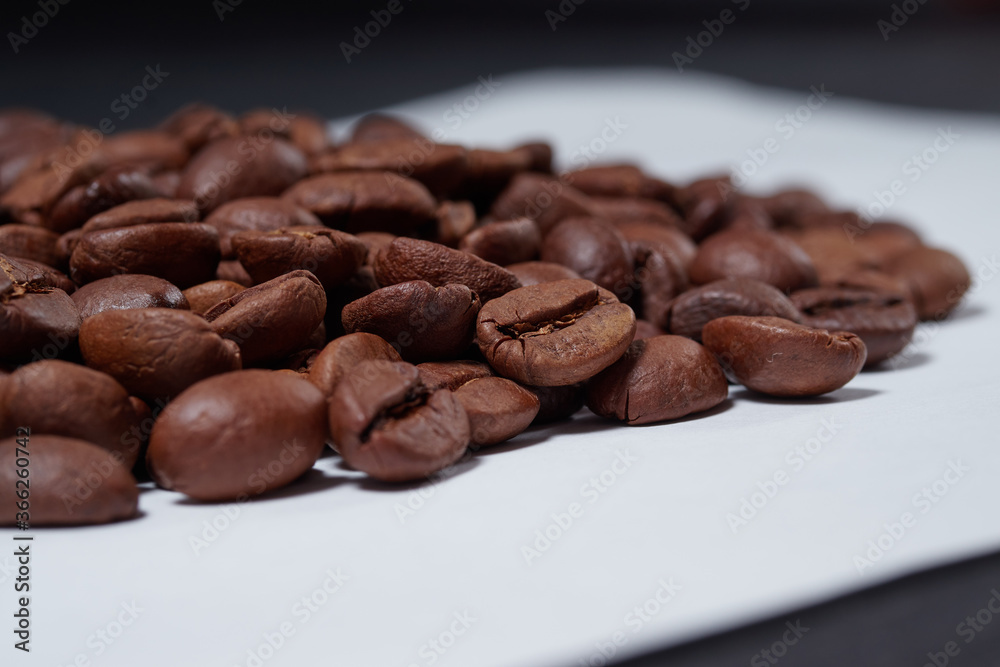 beautiful coffee beans sprinkled on a white table with a black background beautiful coffee beans sprinkled on a white table with a black background