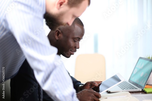 Business professionals. Group of young confident business people analyzing data .using computer while spending time in the office photo