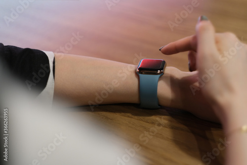 over shoulder view of woman using smart watch. blur background