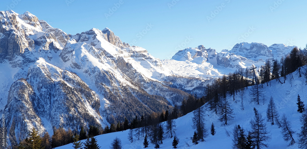 Panorama of snowy mountain Dolomiti landscape with blue sky.