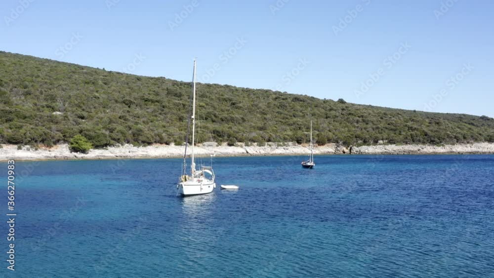 Aerial shot of a adriatic sea bay and sailing boats parked inside. Yacht resting in turquoise and transparent clean sea. Losinj Island, Croatia Aerial shot of a adriatic sea bay and sailing boats parked inside. Yacht resting in turquoise and transparent clean sea. Losinj Island, Croatia