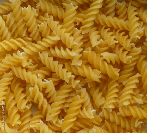 Close-up background/texture of pasta spirals – one of the many forms and shapes of this staple Italian food.