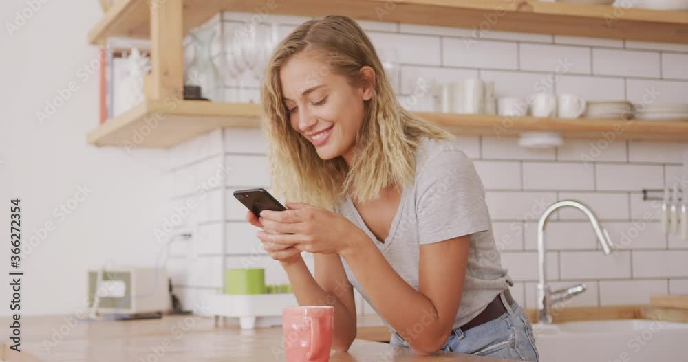 Woman laughing while using smart phone at home Woman laughing while using smart phone at home