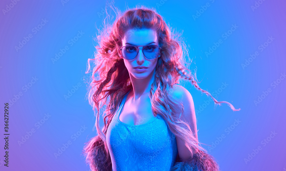 Fototapeta Fashion. Woman in Colorful neon light. Sexy girl in disco bodysuit, makeup. Party disco neon nightclub vibes. Fashionable model portrait, creative art neon pink blue light
