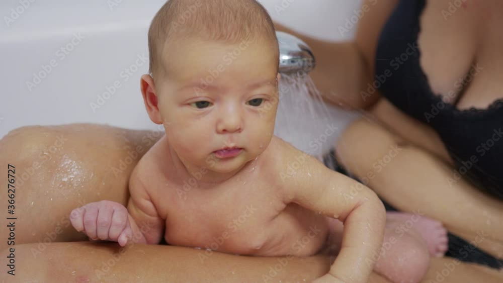 Funny newborn baby during bathing with mother. Funny newborn baby during bathing with mother.