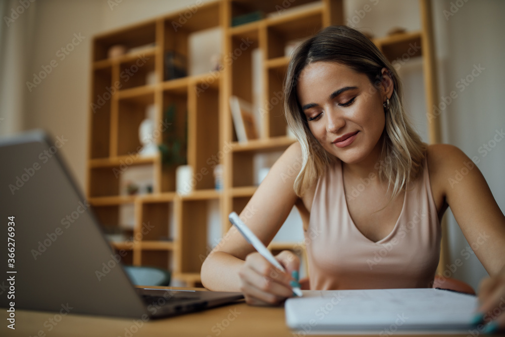 Close-up portrait of a charming young woman taking notes. Close-up portrait of a charming young woman taking notes.
